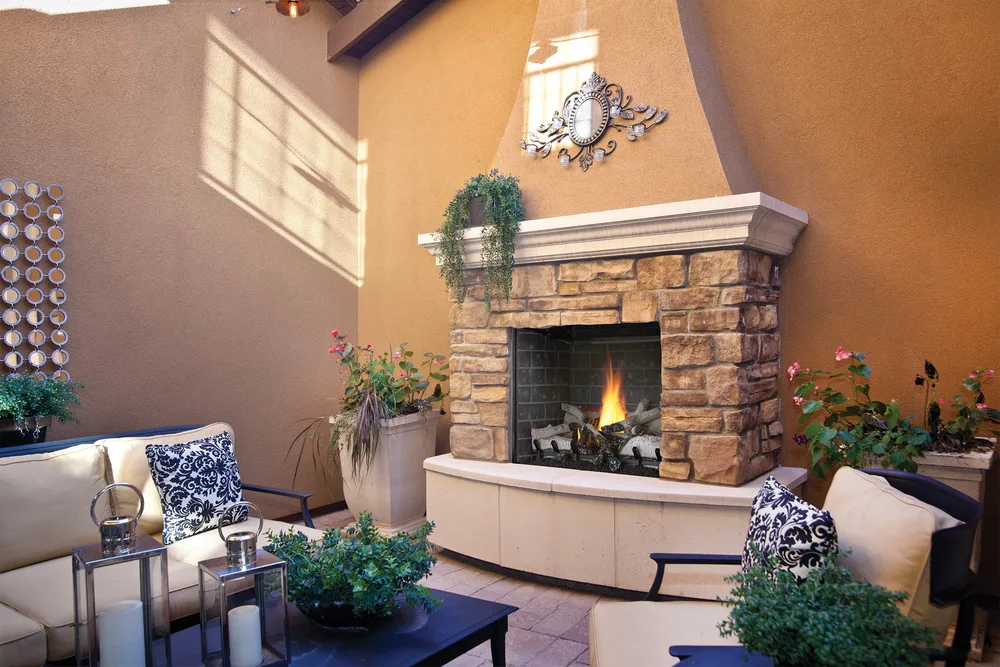 An outdoor fireplace anchoring a covered patio seating area, from our project gallery